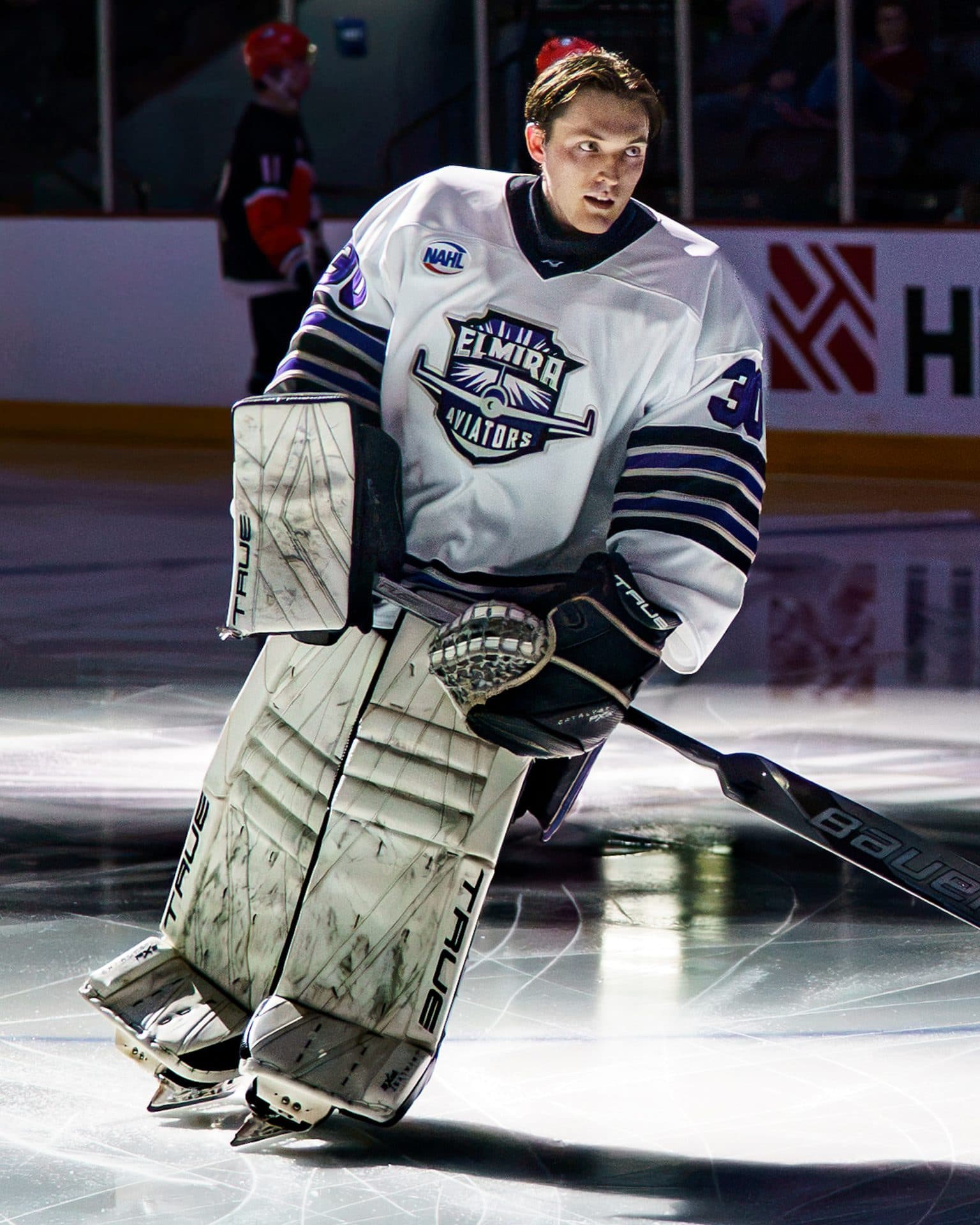 Elmira Aviators goaltender skating out under a spotlight at LECOM Event Center